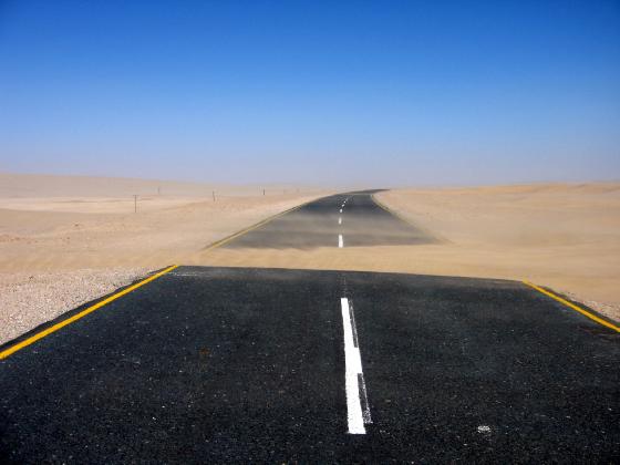 Sand dune blowing across the road