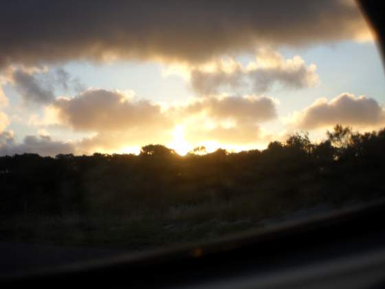 Sunset through the side rear view mirror