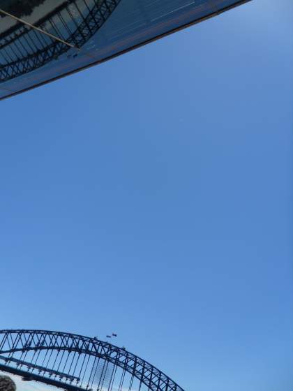 Looking up at Opera House with glimpse of bridge